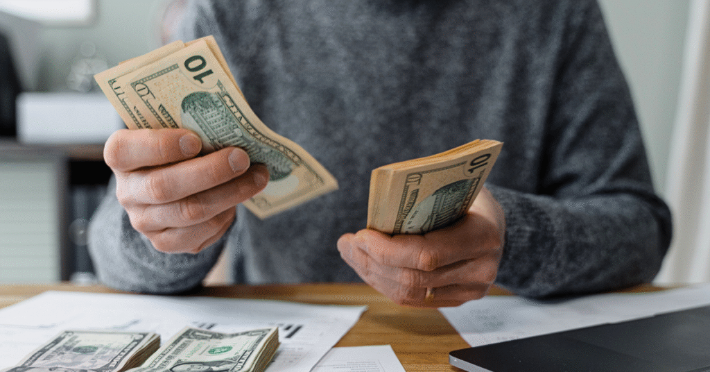 Man counting money, defining what Economics is.