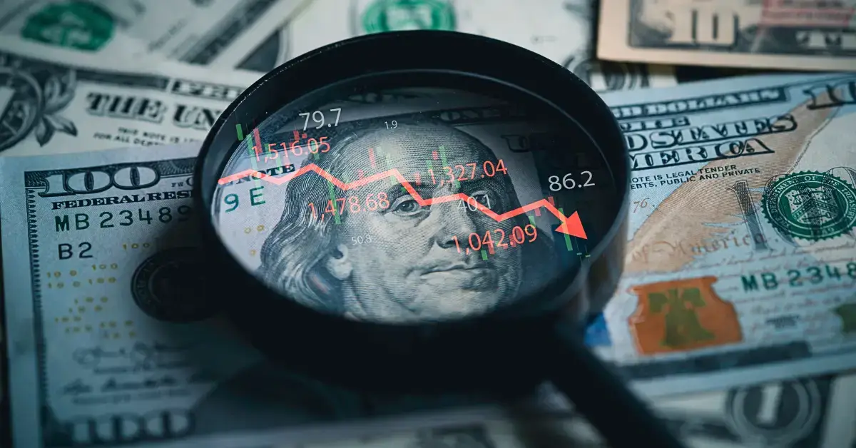 Money with a downtrend arrow and magnifying glass signifying a slowing U.S. Economy due to immigration policies.
